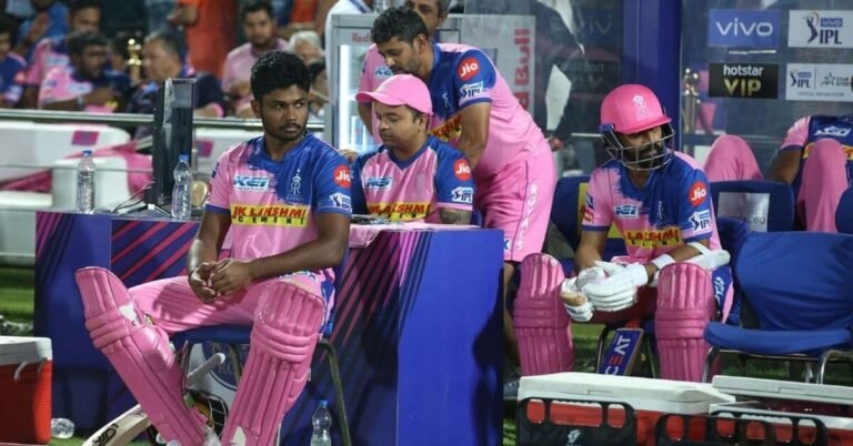 IPL substitute players and support staff watching a match from the dugout